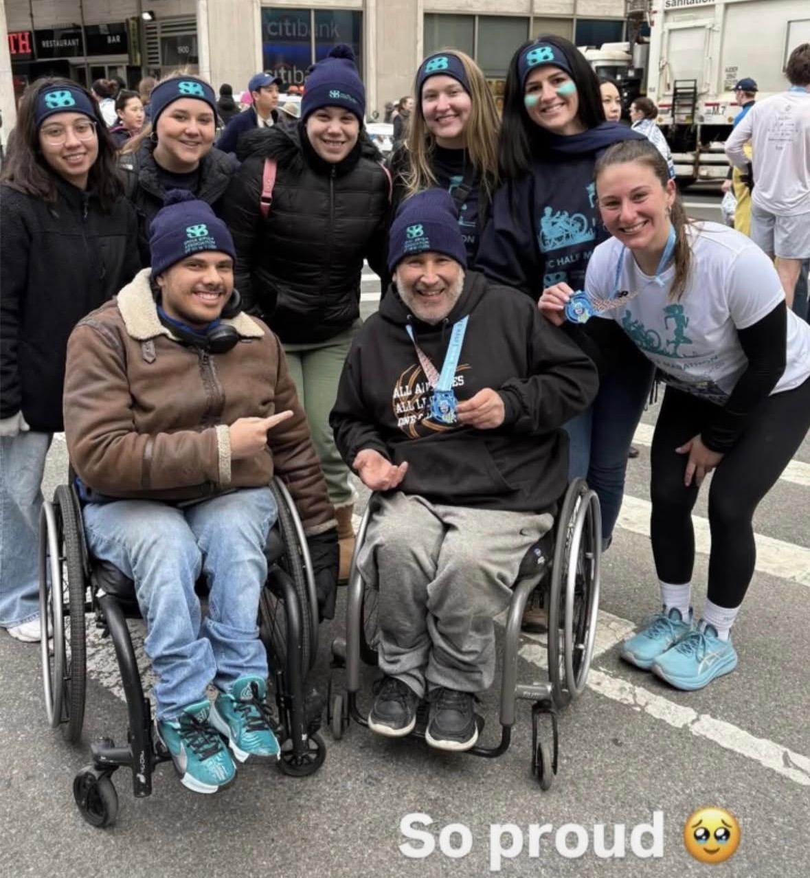 Group with two wheelchair members with caption so proud